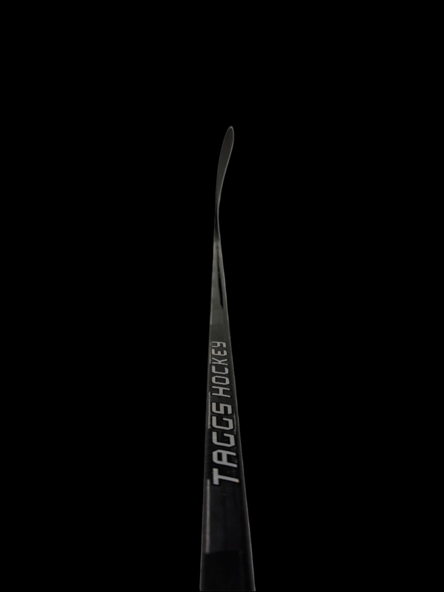 Black hockey stick with 'TAGGS Hockey' branding on a black background