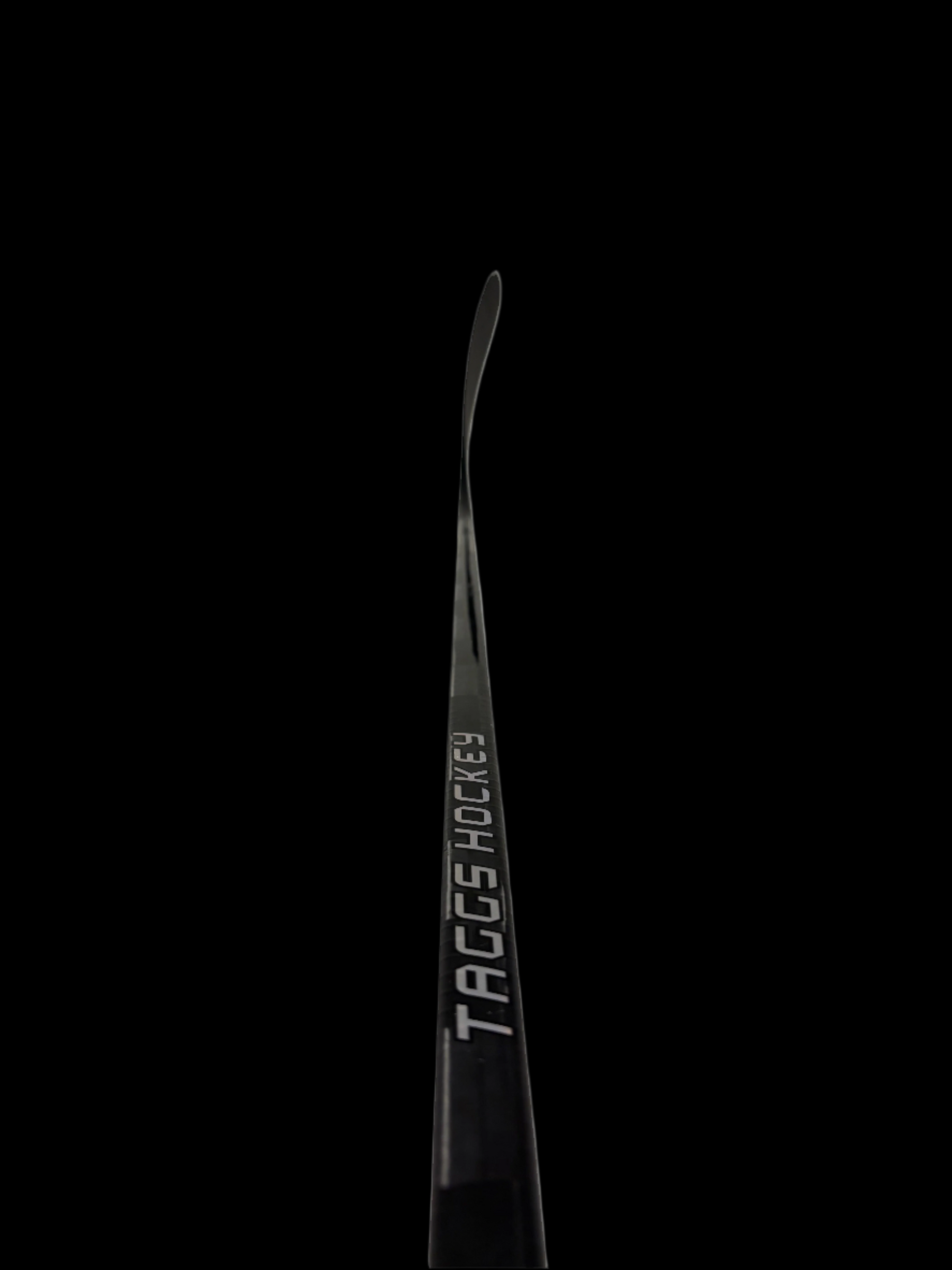 Black hockey stick with 'TAGGS Hockey' branding on a black background
